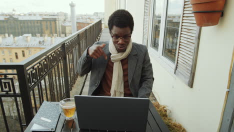 Black-Man-Web-Calling-on-Laptop-on-Rooftop-Terrace
